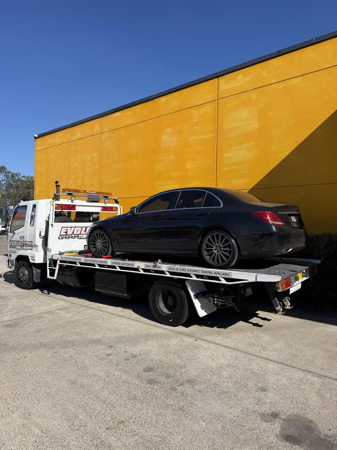 Black Mercedes C-Class on the tray outside a dealership