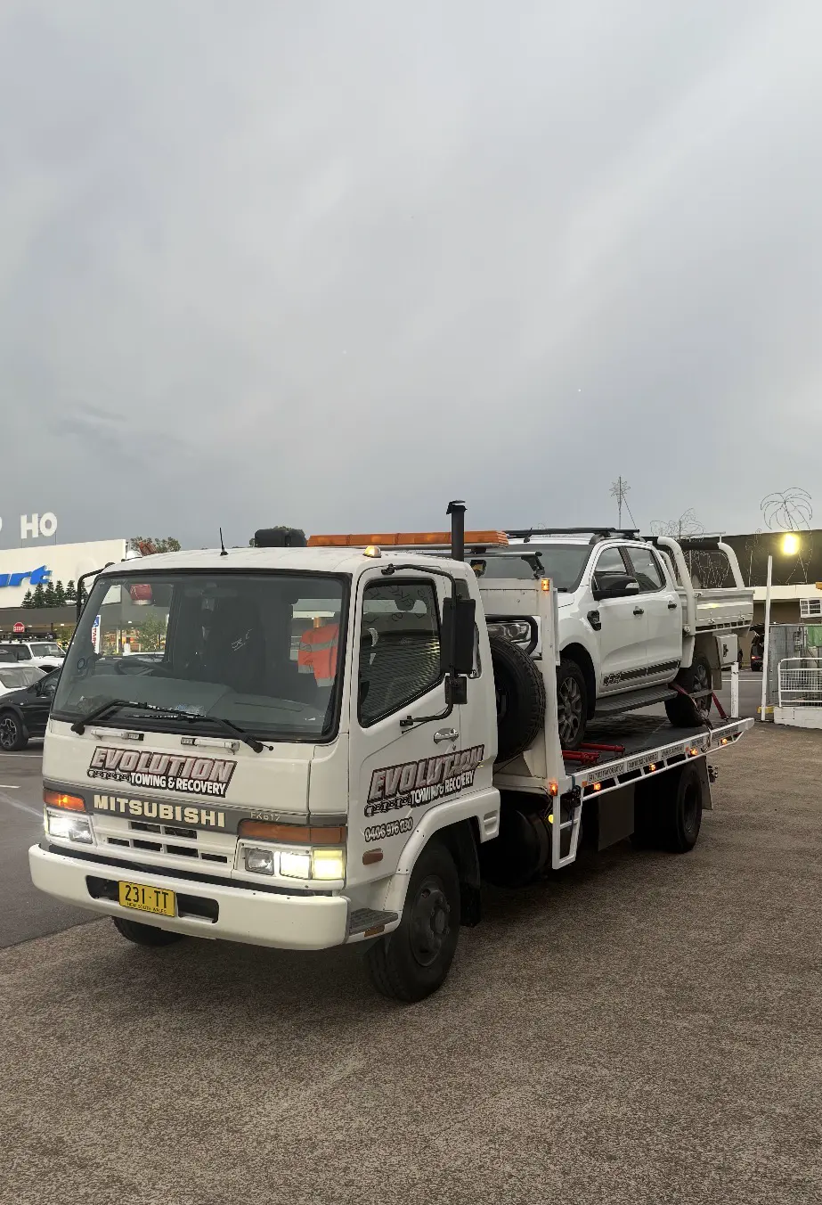 White Ford Ranger ute on the Evolution tilt tray outside a shopping centre